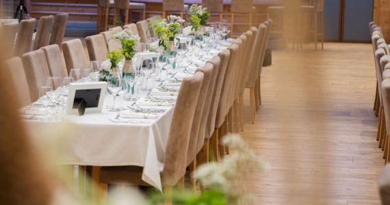 Geräumiger Saal mit Bar beim Gambswirt – der Brauttisch ist vorbereitet, die Tische für die Hochzeitsgäste gedeckt